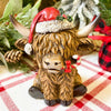 Christmas Highland Cow Figurines - Two Styles are ready for Christmas with their hats - one with a top hat and the other a red Santa Hat. Available at Quilted Cabin Home Decor.