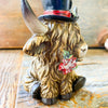 Christmas Highland Cow Figurines - Two Styles are ready for Christmas with their hats - one with a top hat and the other a red Santa Hat. Available at Quilted Cabin Home Decor.