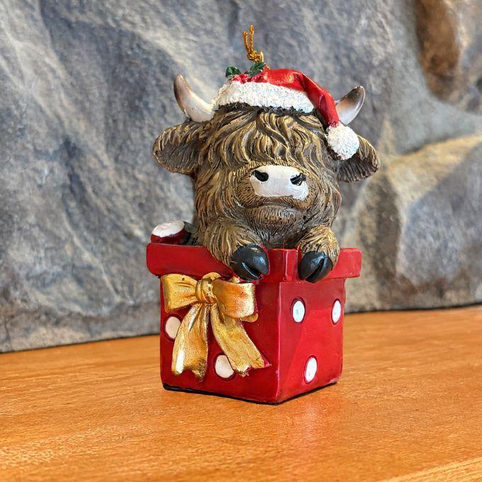 Highland Cow sitting in Christmas present ornament available at Quilted Cabin in Airdrie