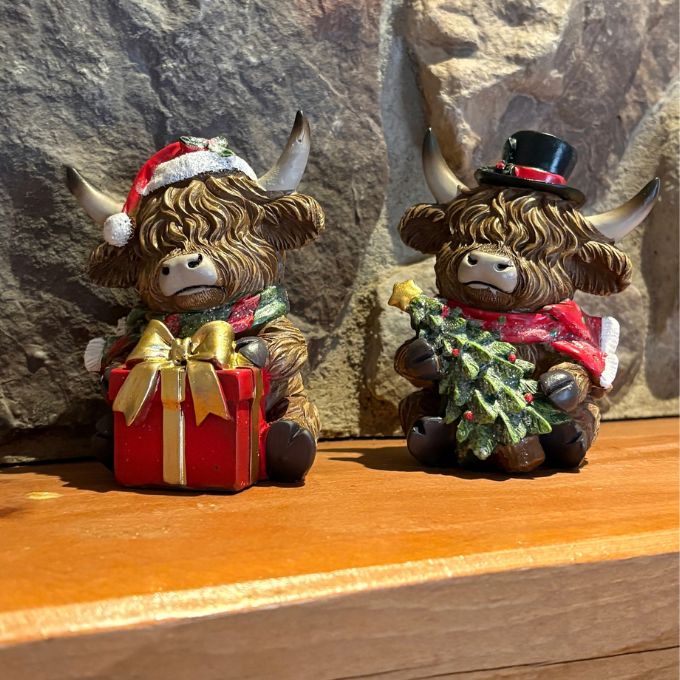 Two festive Christmas highland cows figurines available at Rustic Ranch Furniture in Airdrie