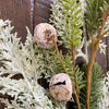 Artificial greenery with frosted jingle bells against a wooden background.  Frosted Cedar & Pine Spray - 30" tall available at Quilted Cabin Home Decor.