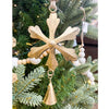 Decorative gold snowflake ornament with a bell hanging on a Christmas tree. Vintage Gold Snowflake Ornaments - Set of Three available at Quilted Cabin  Home Decor.