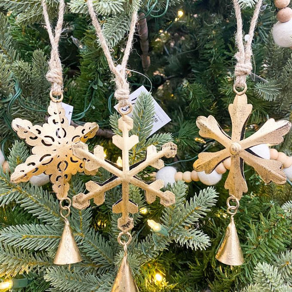 Decorative gold snowflake ornaments with bells hanging on a Christmas tree. Vintage Gold Snowflake Ornaments - Set of Three available at Quilted Cabin  Home Decor.