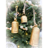 Gold bell ornaments hanging on a decorated Christmas tree. Gold Clapper Bells - Three Sizes available at Quilted Cabin Home Decor.