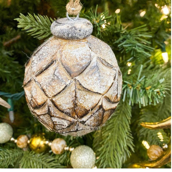 Decorative Christmas ornament on a tree with lights. Mango Wood Pine Ball Ornament available at Quilted Cabin Home Decor.
