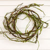A mossy candle ring with green moss, displayed against a white wood plank background.  Available at Quilted Cabin in Airdrie