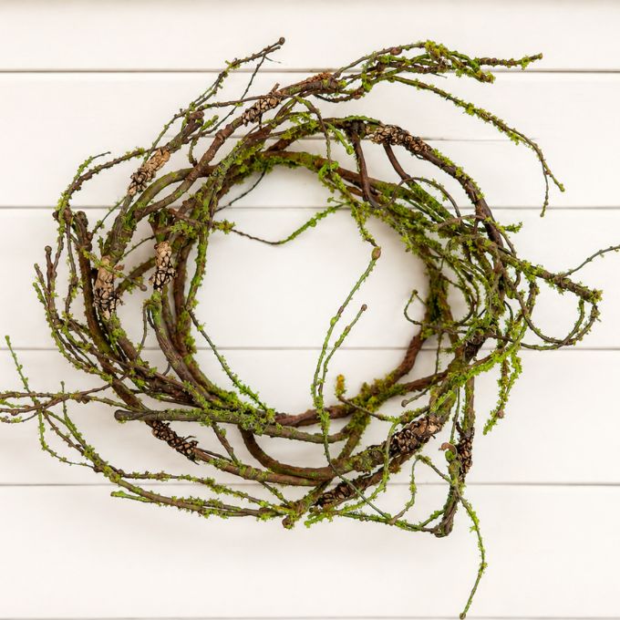A mossy candle ring with green moss, displayed against a white wood plank background.  Available at Quilted Cabin in Airdrie