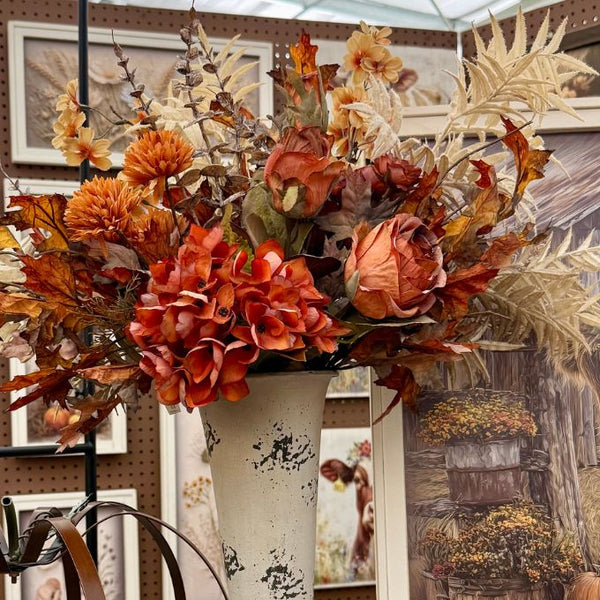 Two artificial flowering branches with peach, orange, and cream blossoms on brown stems, displayed against a dark gray background.  Available on line at quilted cabin or at Rustic Ranch furniture in Airdrie