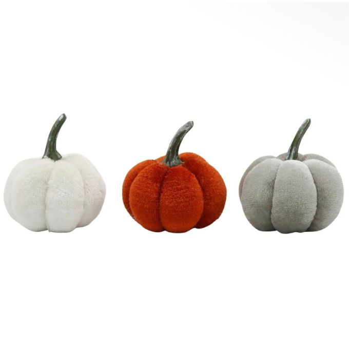 Three small plush pumpkin decorations on a plain white background, shown in white, orange, and light gray, each with a dark stem.  Decorative pumpkins available at Quilted Cabin in Airdrie