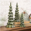 Three tiered pine tree ornaments in a textured dark green finish, displayed on a wooden mantel with books and holiday greenery.  Small and large trees available at Quilted Cabin in Airdrie