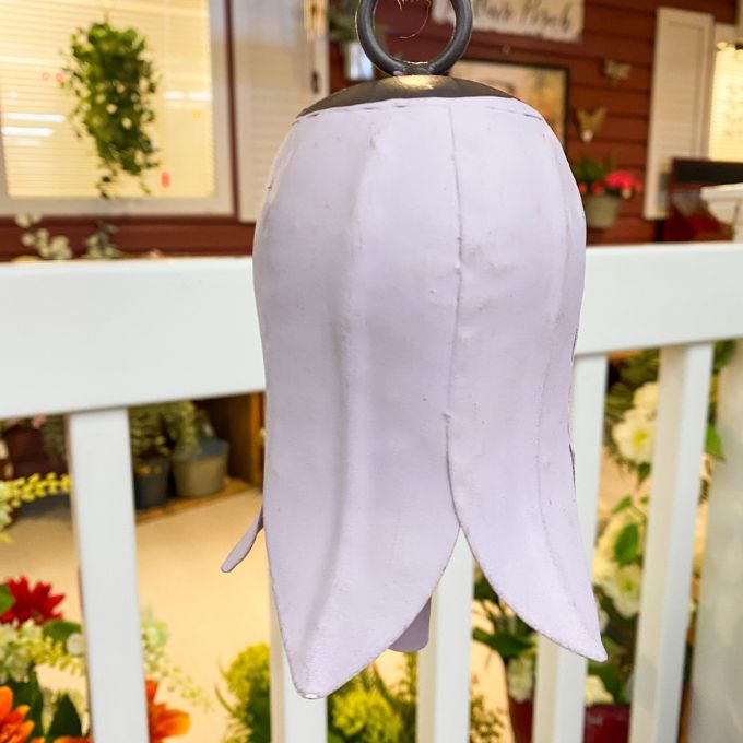 White tulip bell hanging on a white railing with a blurred indoor background. Tulip Bells - Three Colours available at Quilted Cabin Home Decor.
