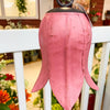 Pink tulip bell hanging on a white railing with a blurred indoor background. Tulip Bells - Three Colours available at Quilted Cabin Home Decor.