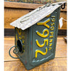 Birdhouse made from a repurposed Pennsylvania license plate on a wooden surface. Recycled License Plate Birdhouse available at Quilted Cabin Home Decor.