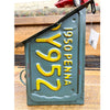 Vintage-style license plate with '1950 PENNA 952' on a wooden surface. Recycled License Plate Birdhouse available at Quilted Cabin Home Decor.