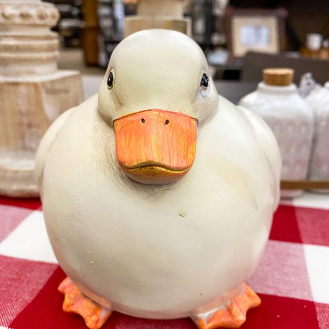 White ceramic duck with an orange beak on a red and white checkered tablecloth.  Chubby White Resin Duck Figurine available at Quilted Cabin Home Decor.