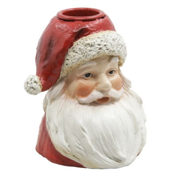 A Santa Claus-themed ceramic planter shaped like Santa's head, featuring a red hat with a white textured trim and pom-pom, a painted face, and a long white beard. The top of the hat has a circular opening for a tapered candle.  Available at Quilted Cabin in Airdrie