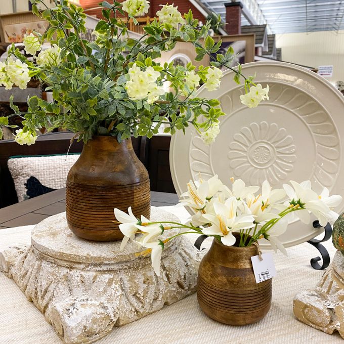 Decorative wooden vases with flowers on a table in an indoor setting. Distressed Round Wooden Vases - Two Sizes available at Quilted Cabin Home Decor.