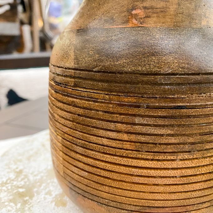 Close-up of a wooden vase with a textured surface. Distressed Round Wooden Vases - Two Sizes available at Quilted Cabin Home Decor. 