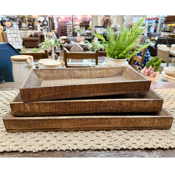 Three Reclaimed Wooden tray stacked on a textured surface.  Reclaimed Wooden Trays come in three sizes and are available at Quilted Cabin Home Decor