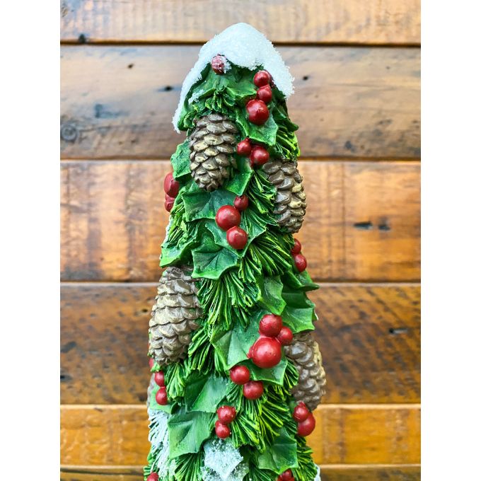 Decorative Christmas tree figurine with green leaves, red berries, and pinecones against a wooden background. Pine Christmas Tree Figurine available at Quilted Cabin Home Decor.
