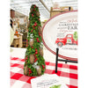 Decorative Christmas tree with pinecones and berries on a red and white checkered tablecloth, with a sign in the background. Pine Christmas Tree Figurine available at Quilted Cabin Home Decor.