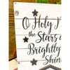 Oh Holy Night Nativity Sign is a white planked block sign with black printing and nativity cutout. It is available from Quilted Cabin Home Decor.