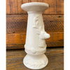 White decorative pillar candle holder with embossed deer on a wooden background. Christmas Deer Pillar Candle Holder available at Quilted Cabin Home Decor.