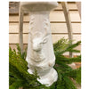 Decorative white pedestal with deer heads on a background of greenery. Christmas Deer Pillar Candle Holder available at Quilted Cabin Home Decor.