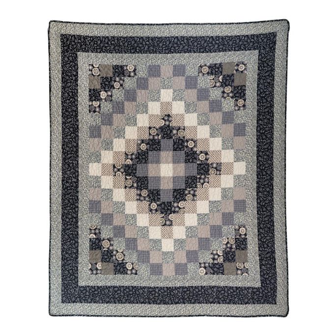 Patchwork quilt with geometric pattern on a white background. Lexington Trip Throw Quilt available at Quilted Cabin Home Decor.