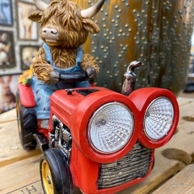 Highland Cow Tractor Solar Figurine available at Quilted Cabin Home Decor.
