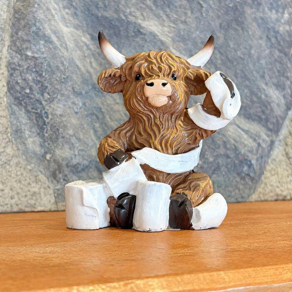 Resin highland cow figurine wrapped in toilet paper available at Quilted Cabin in Airdrie