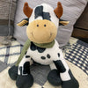 Plush cow toy on a checkered blanket with a plaid fabric background.  Moo Cow Stuffie available at Quilted Cabin Home Decor.