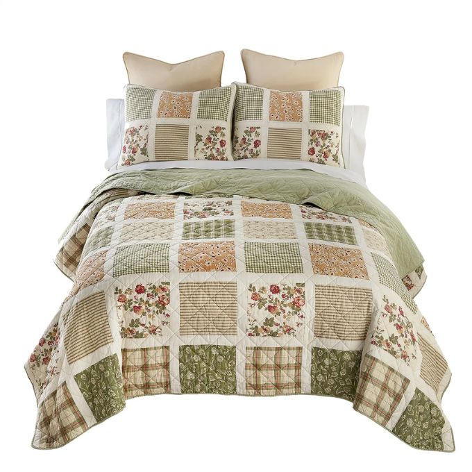Patchwork quilt set with floral patterns on a white background. Peach Rose Quilt Set available at Quilted Cabin Home Decor.