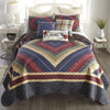 Quilted bedspread with geometric pattern on a bed in a bedroom setting. Chesapeake King Quilt Set available at Quilted Cabin Home Decor.