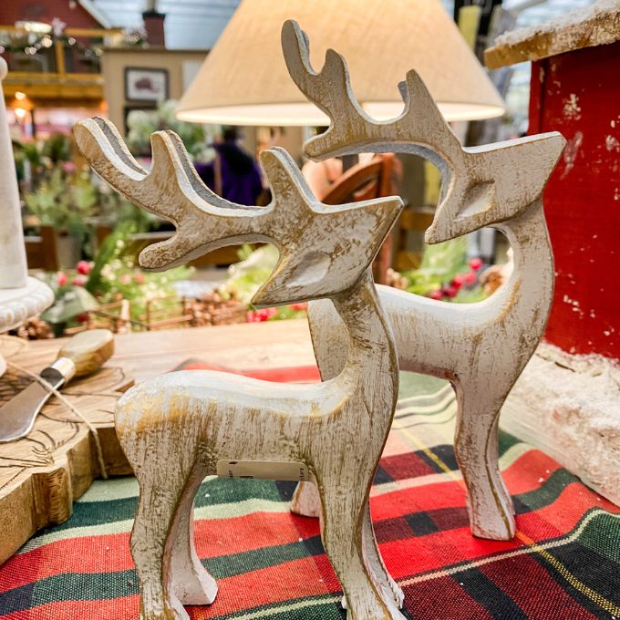 Decorative aluminum reindeer figure on a plaid fabric with a blurred indoor background. Aluminum reindeer available at Quilted Cabin Home Decor.
