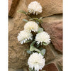 Artificial white flowers with green leaves against a stone wall background. Amaranth Floral Stems - Three Colours available at Quilted Cabin Home Decor.