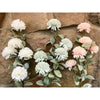 Artificial flower garland with white, blue and pink flowers against a stone wall background. Amaranth Floral Stems - Three Colours available at Quilted Cabin Home Decor.