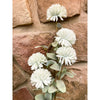 White flowers with green leaves against a stone wall background. Amaranth Floral Stems - Three Colours available at Quilted Cabin Home Decor.