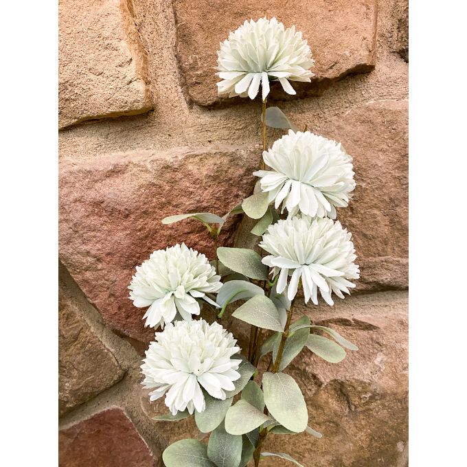 White flowers with green leaves against a stone wall background. Amaranth Floral Stems - Three Colours available at Quilted Cabin Home Decor.