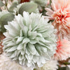 Close-up of a light green flower with pink flowers in the background. Amaranth Floral Stems - Three Colours available at Quilted Cabin Home Decor.