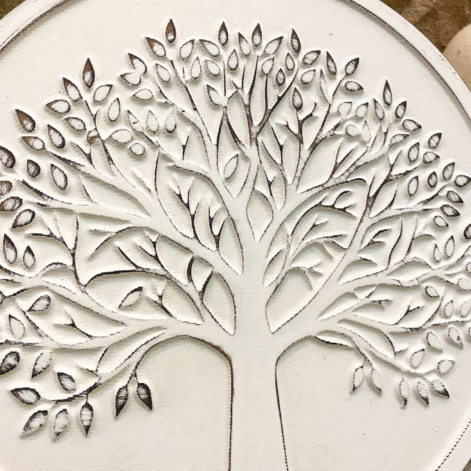 Close-up of a tree design on a white surface. Whitewashed Tree of Life Wall Art available at Quilted Cabin Home Decor.