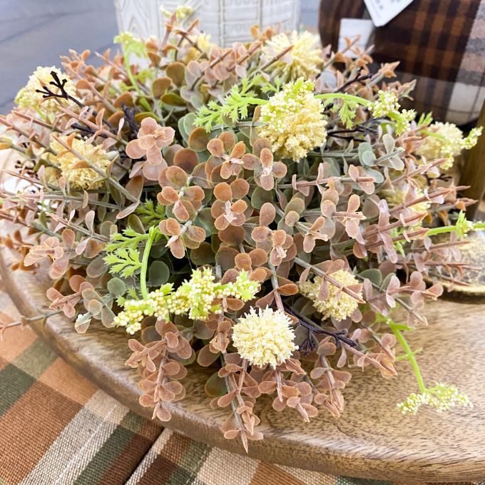 Decorative arrangement of artificial plants on a wooden surface. Cream Pincushion Half Floral Sphere available at Quilted Cabin Home Decor.