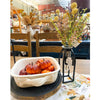 Decorative setup with pumpkins in a basket and flowers in a vase on a table. Cream Pincushion Floral Spray available at Quilted Cabin Home Decor.