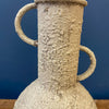 Textured ceramic vase with handles on a blue background. Rustic Metal Vases - Two Colours available at Quilted Cabin Home Decor.