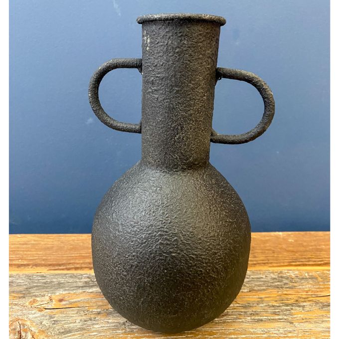 Black textured vase with handles on a wooden surface and blue background. Rustic Metal Vases - Two Colours available at Quilted Cabin Home Decor.