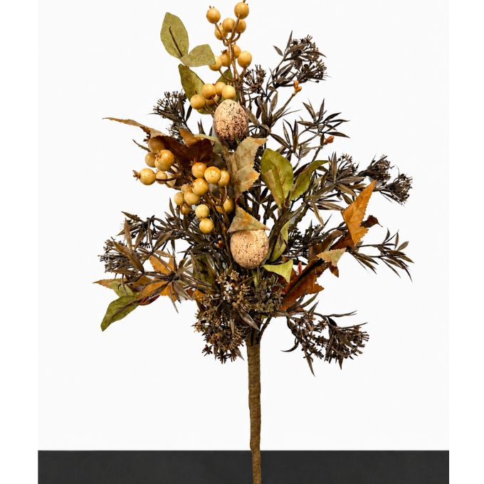 A dried autumn floral arrangement featuring brown pine needles, tan acorns, and clusters of small beige berries on a single stem, photographed against a white background with a dark strip at the bottom. Available at Quilted Cabin in Airdrie