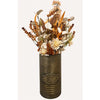A dried floral arrangement in a ribbed cylindrical metal tin vase with embossed branding reading 'Old World Gardens'. The bouquet features cream, tan, and brown botanicals with muted foliage, set against a plain off-white background. All items available at Quilted Cabin in Airdrie