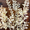 Artificial leaf branches on a wooden surface. Tan Leaf Stem Spray available at Quilted Cabin Home Decor.