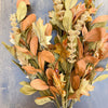 Autumn-themed wreath with leaves and berries on a wooden surface. Maple Leaf and Walking Fern Floral Spray available at Quilted Cabin Home Decor.