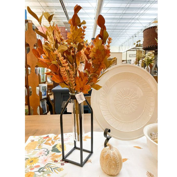 Decorative items including a vase with autumn leaves, a white plate, and a small pumpkin on a store shelf. Maple Leaf and Walking Fern Floral Spray available at Quilted Cabin Home Decor.